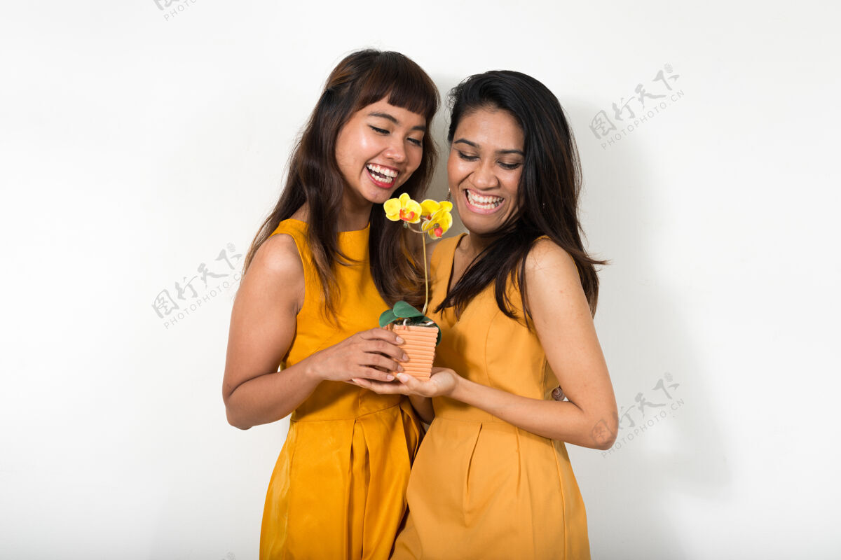 泰国两个年轻的亚洲女人一起对抗白色空间浪漫拍摄女性