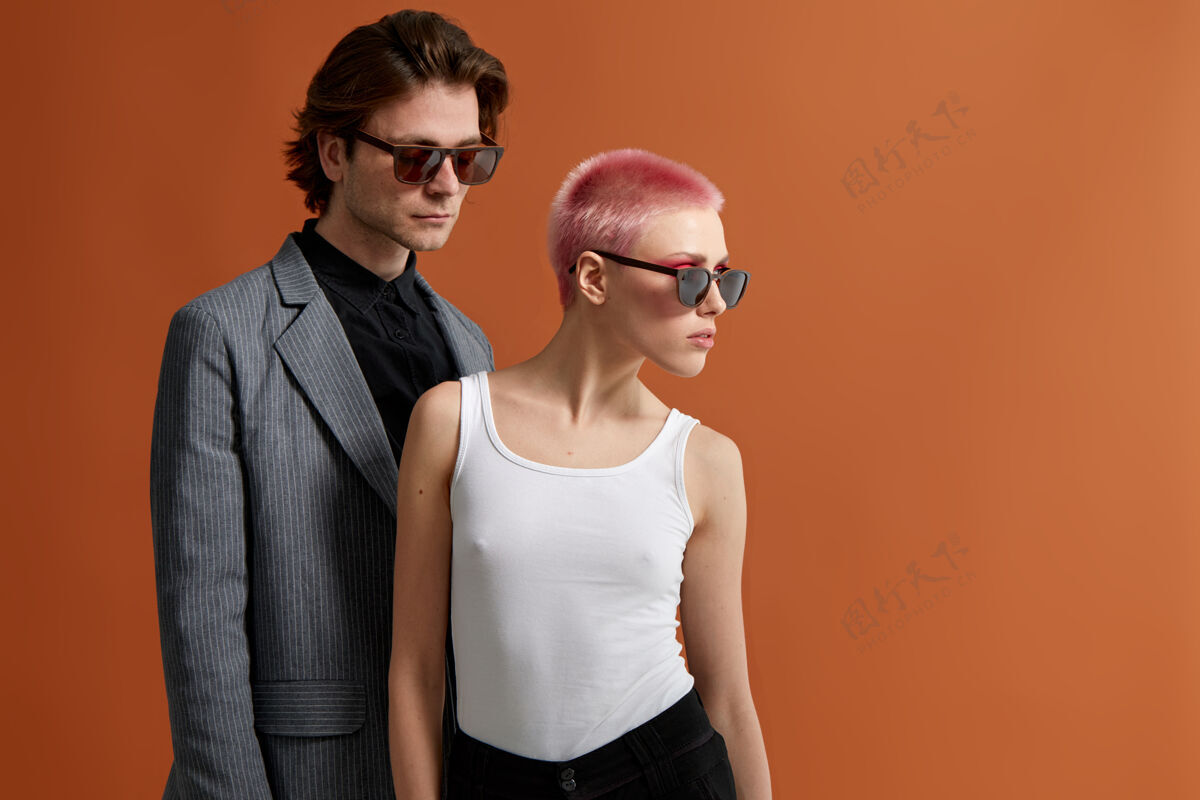 姿势戴着太阳镜的时髦年轻情侣 一起摆姿势发型工作室时尚