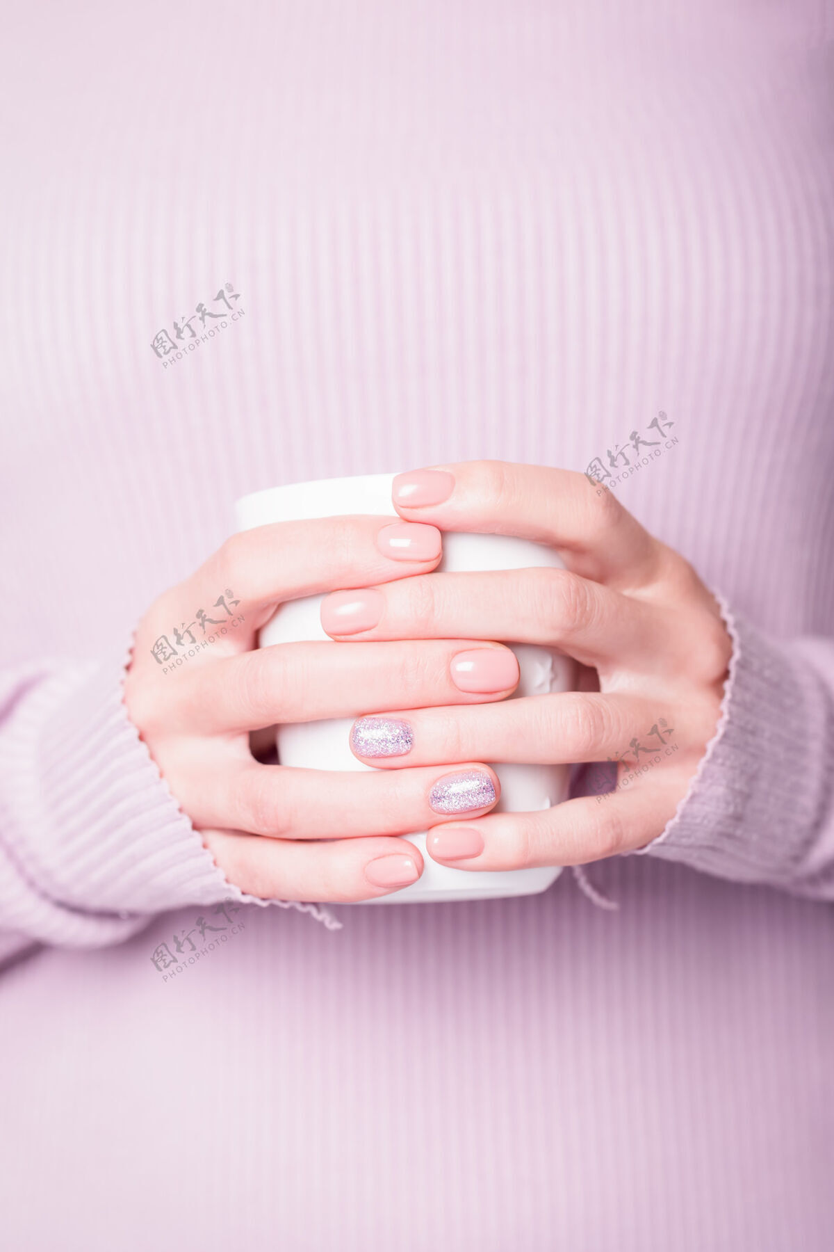 指甲女性手拿白色杯子 用粉色指甲油修指甲护理苍白杯子