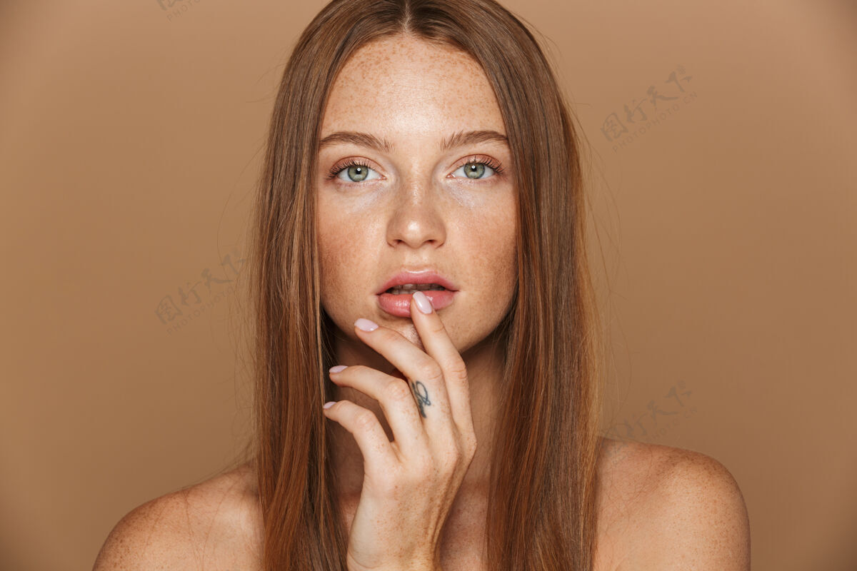 皮肤一个性感的年轻裸体女人的美丽肖像 留着长长的红色头发 手拉着她隔离在米色墙上的脸面霜生姜漂亮