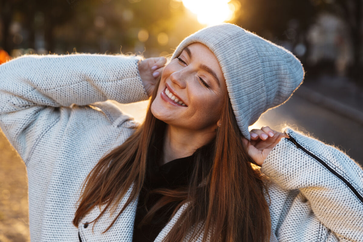 装装装一个穿着秋衣 头戴秋帽 在城市街道上走在户外的快乐的年轻女子情感自然年轻