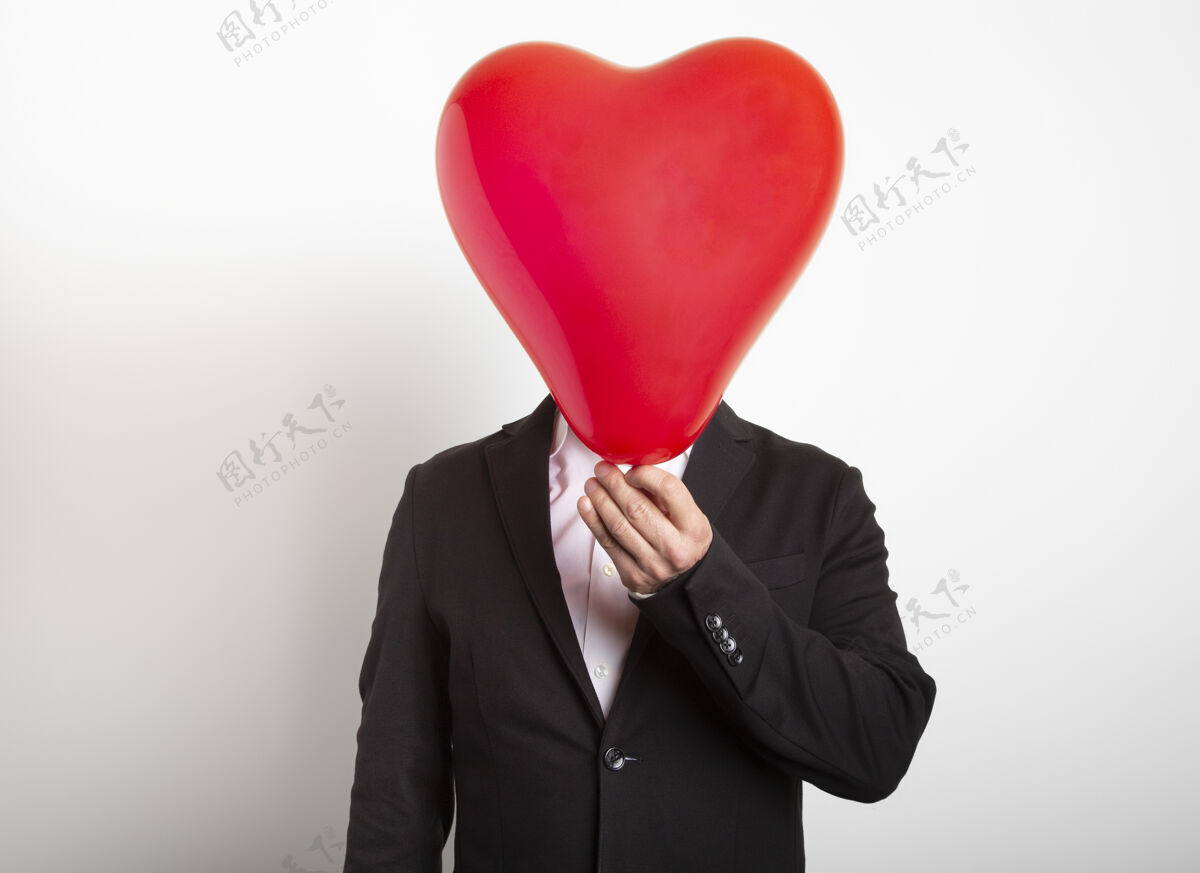 男性一个穿西装的男人躲在一个红色的心形气球男手持爱 家庭 希望的象征快乐肖像经典