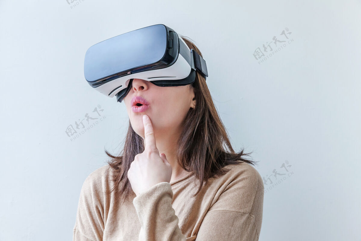 设备微笑的年轻女子戴着虚拟现实vr眼镜头盔耳机在白色背景上游戏体验手表