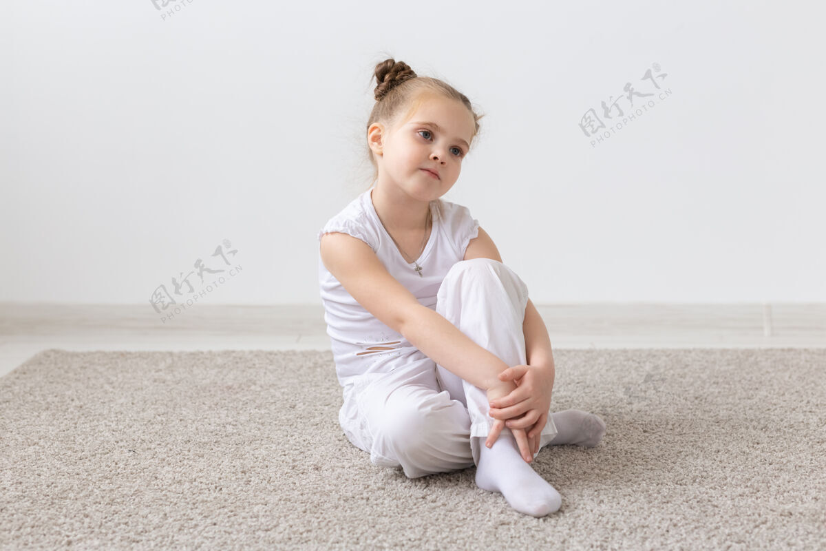 小穿白衬衫的孩子坐在地板上年轻沉思小
