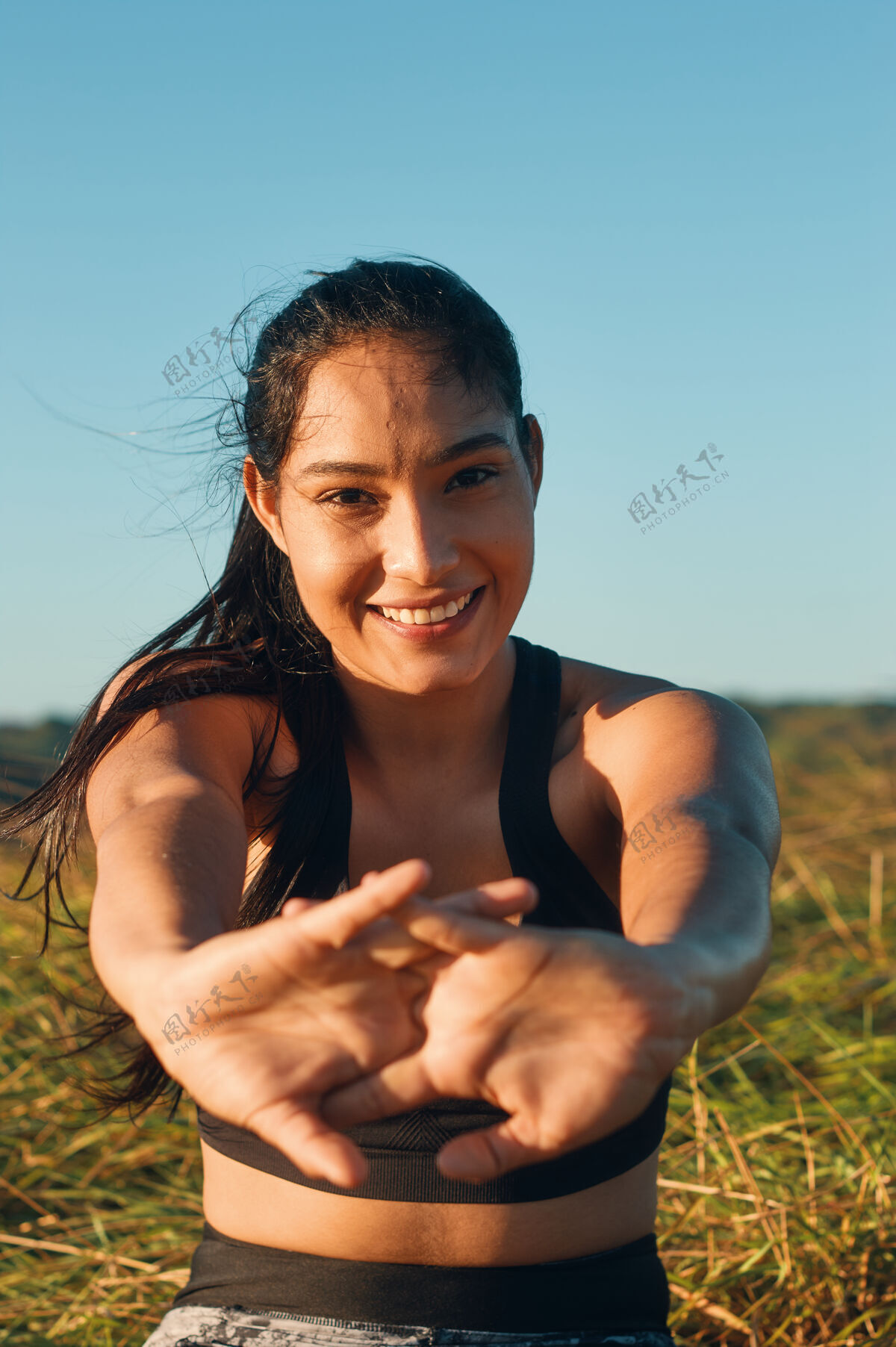 女人一个快乐的女人在户外伸展身体的浅焦镜头拉美裔温暖活跃