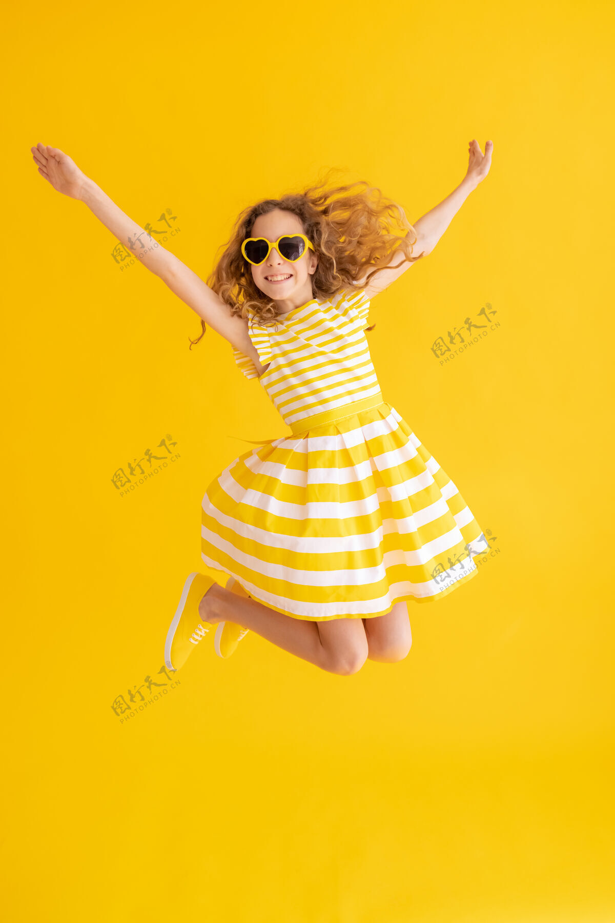 内快乐的孩子在黄色的夏日水面上跳跃孩子健康活跃
