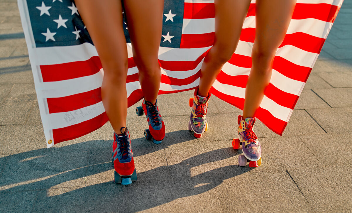 运动在阳光明媚的日子里 穿着比基尼 举着美国国旗 在海滩附近玩旱冰鞋的女人的剪短照片海滩周末美国