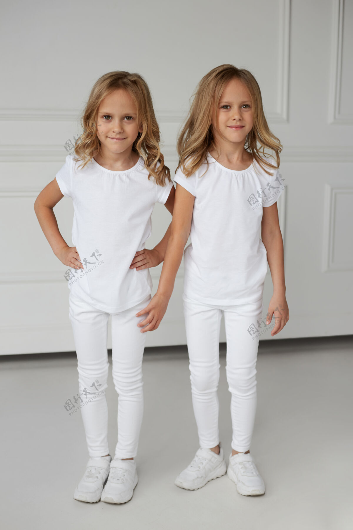 金发一对穿着白色衣服的双胞胎姐妹手牵手孤立的完整图像姐姐白布姿势