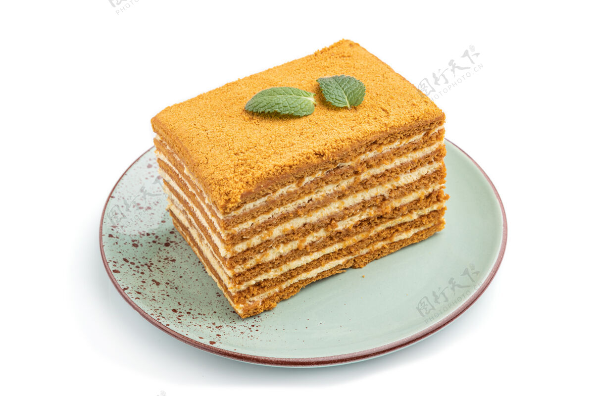 质地自制蜂蜜蛋糕与牛奶奶油和薄荷隔离在白色表面奶油卡路里分层