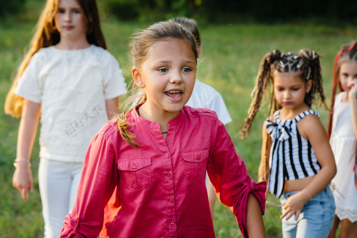 玩日落时分 一群快乐的孩子在公园里奔跑玩耍夏令营小学生活跃游戏
