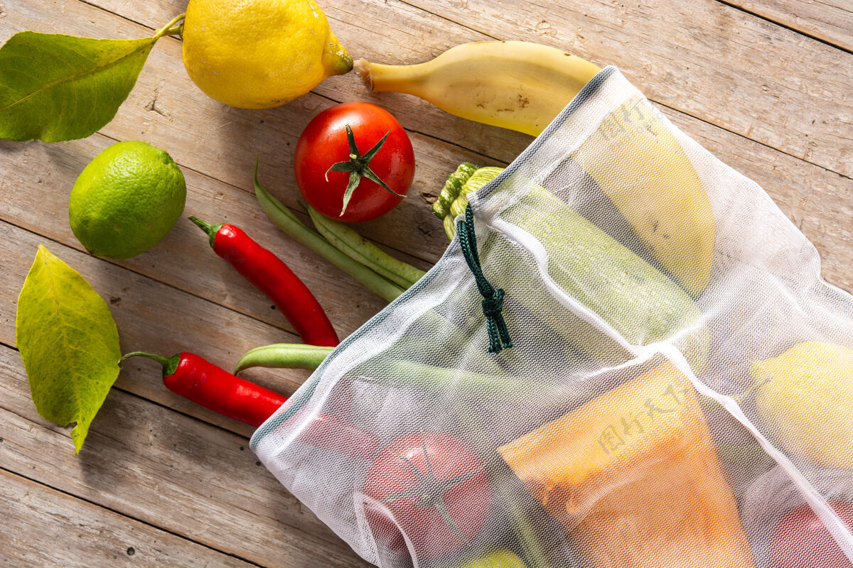 环境环保的可重复使用的购物袋与蔬菜和水果在木桌上香蕉柠檬木材