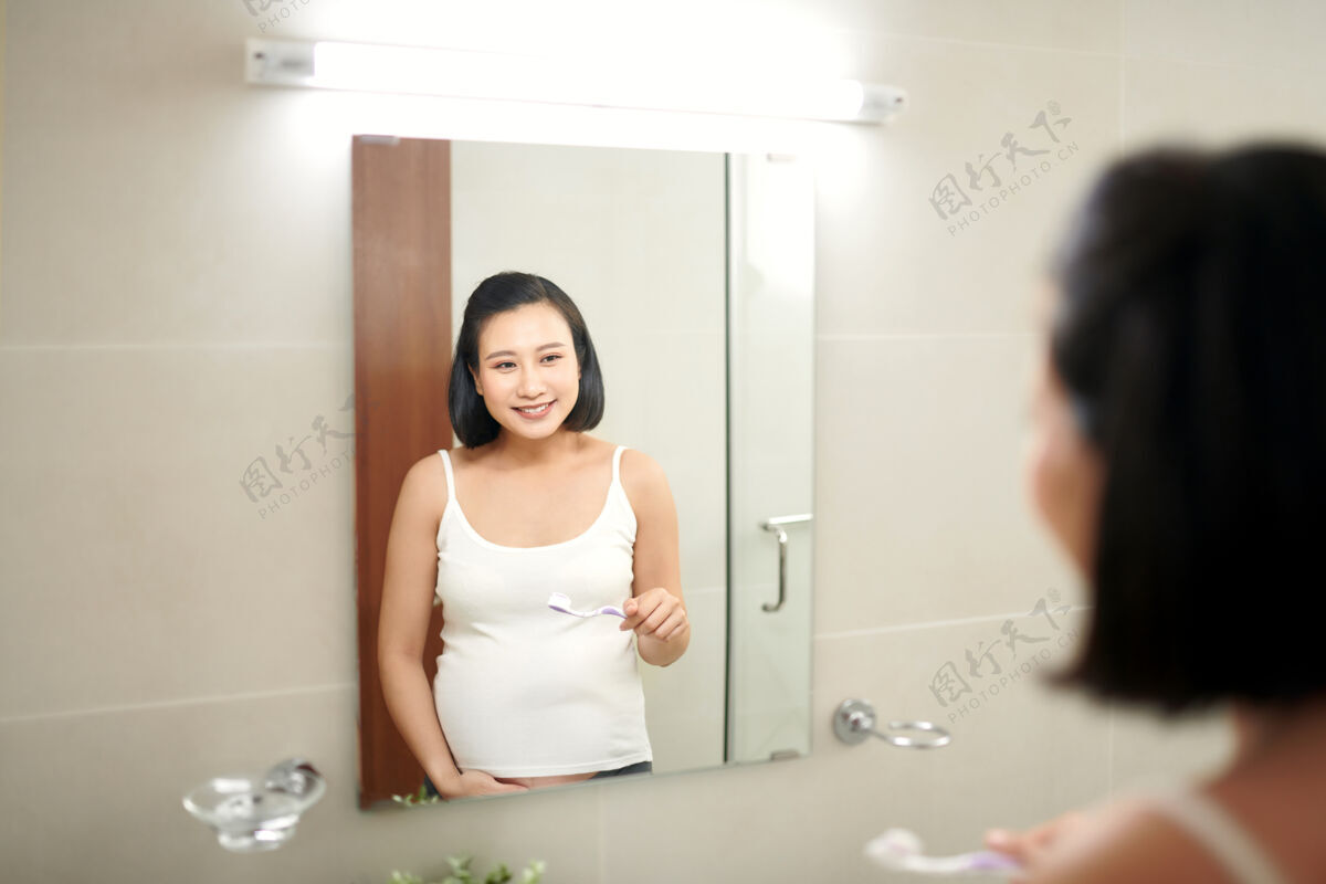 护理年轻孕妇在浴室刷牙的画像牙科孕妇年轻人