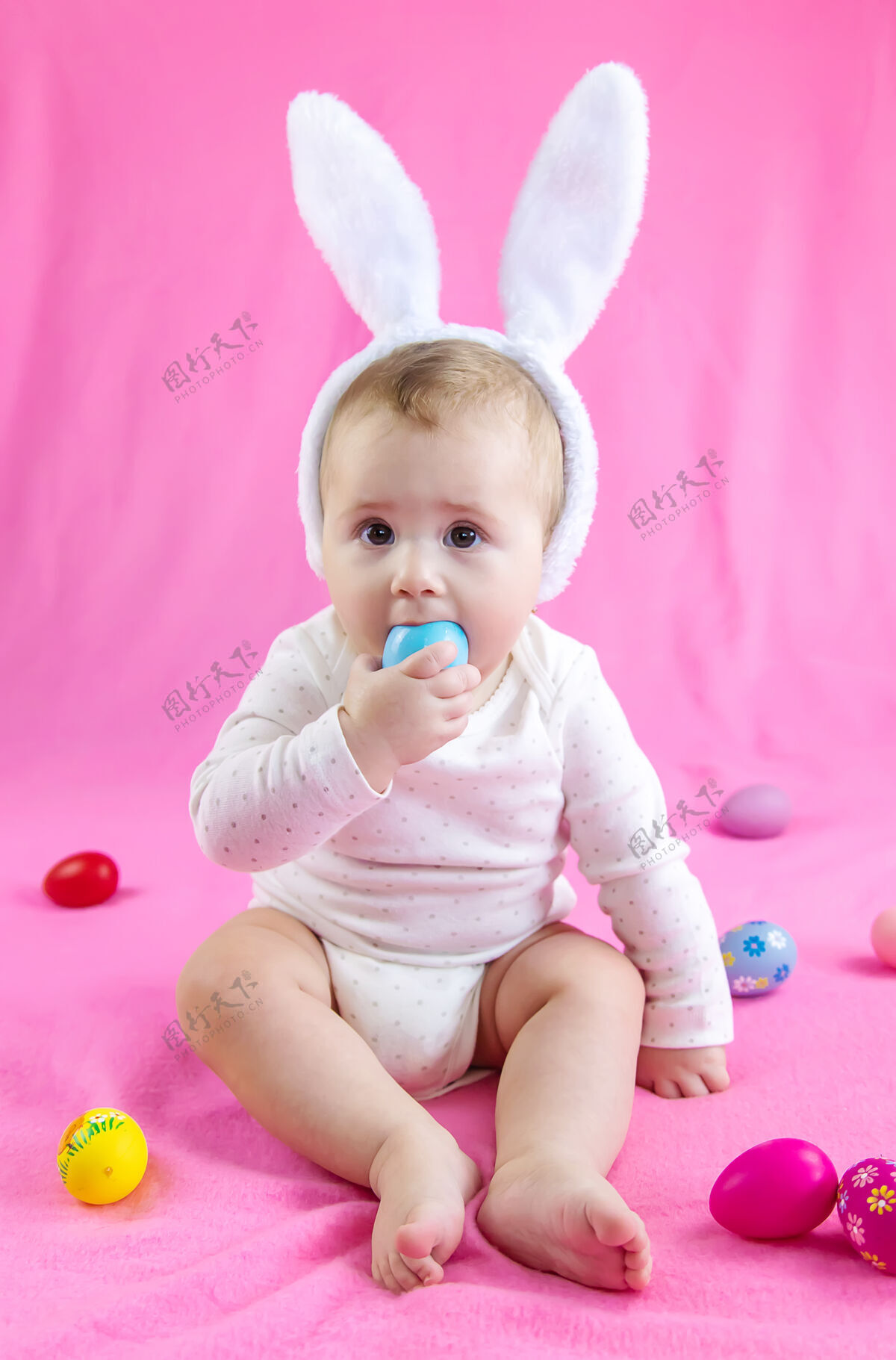 孩子穿得像兔子的宝宝 带着复活节彩蛋过复活节服装抱着老