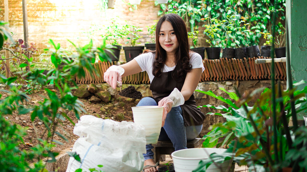 农场亚洲女人用花盆准备种植的地方雌性开花盆栽