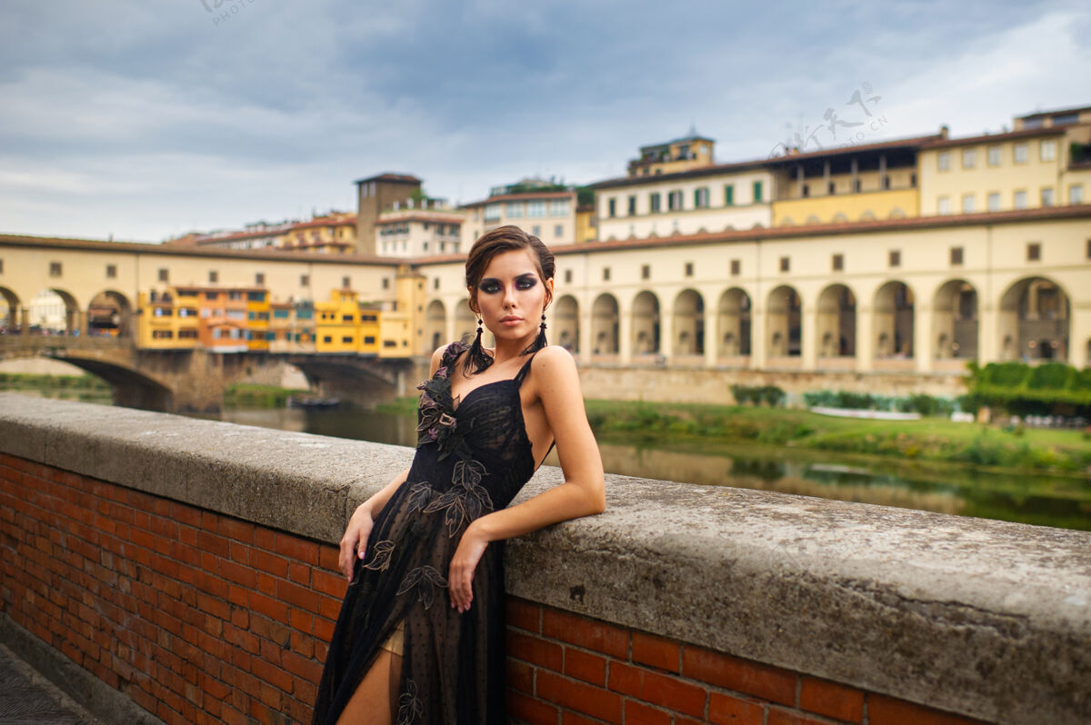女士在意大利佛罗伦萨 身着黑色礼服的美丽时尚新娘站在堤岸上女人佛罗伦萨新娘