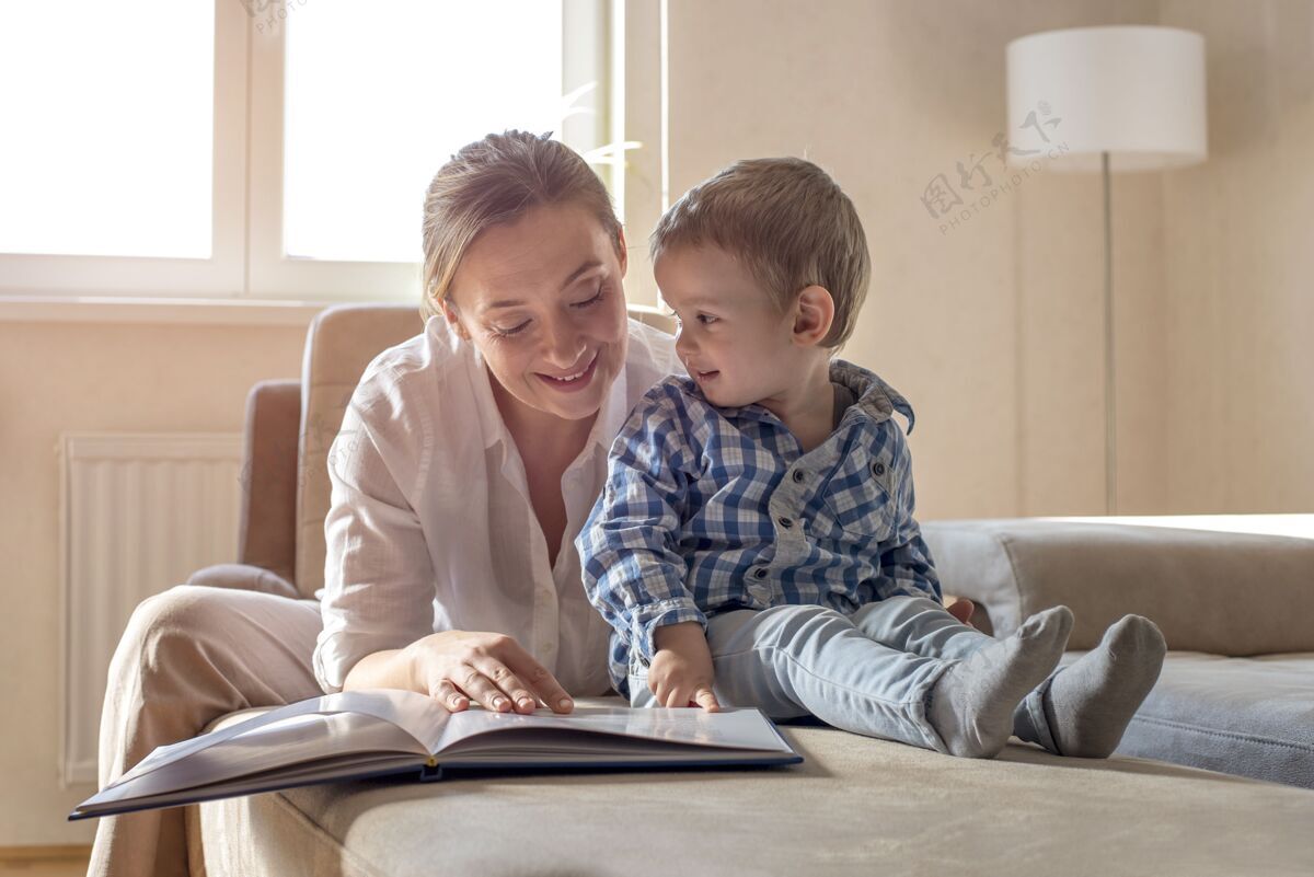 女人妈妈在家给小儿子看书男孩在一起小