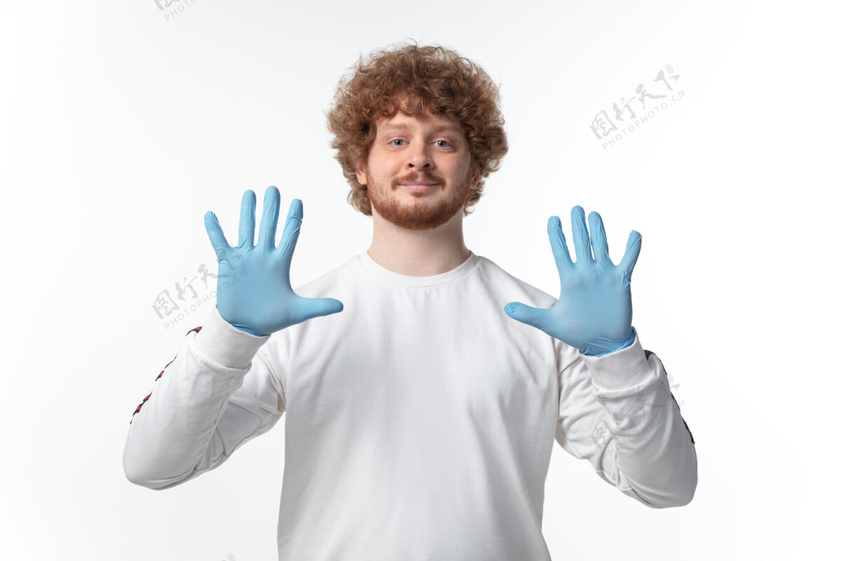 呼吸白墙上戴着蓝手套的年轻人诊断消毒中国