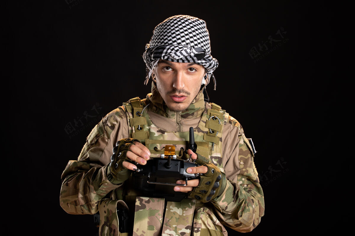 成人巴勒斯坦士兵在黑墙上用遥控器制服肖像黑人