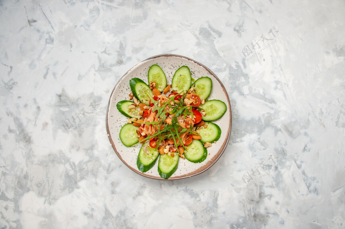 色斑俯瞰美味沙拉装饰切碎黄瓜和绿色染色白色表面与自由空间黄瓜午餐食物