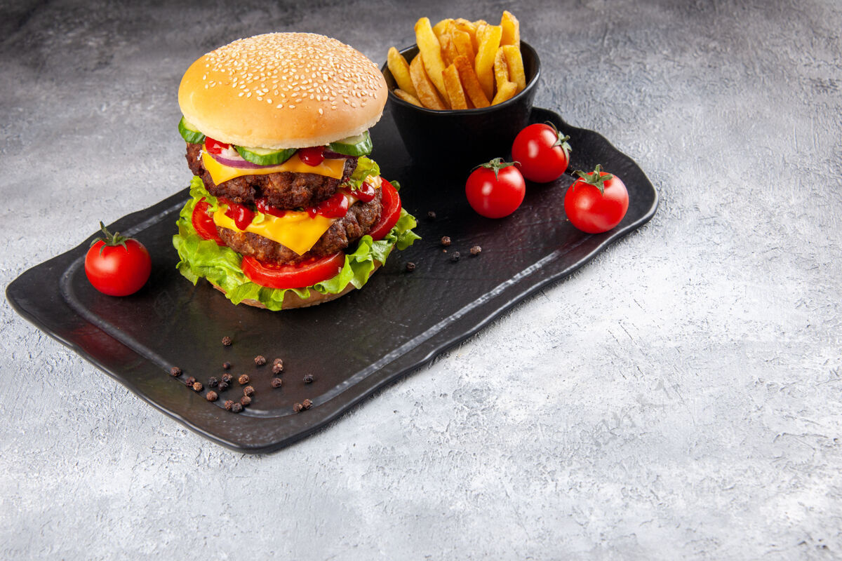 沙拉美味的自制三明治和油炸番茄酱在右边的灰色冰面上的黑板上午餐番茄冰