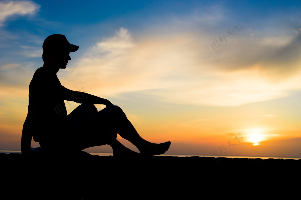 冷一个男人坐在海边的剪影自然暮色海洋