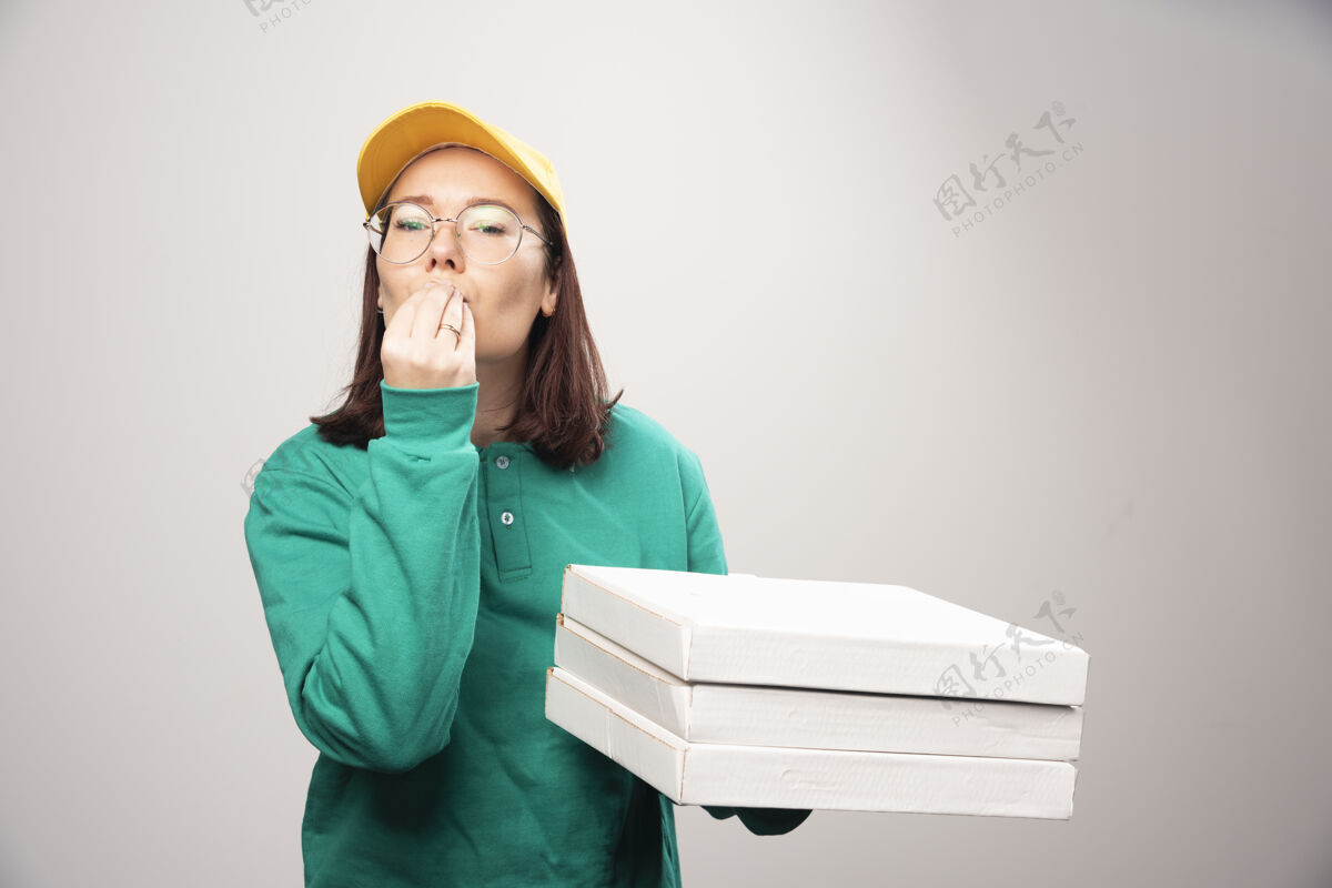 制服送货员拿着一张白色的高质量的比萨饼卡片成人美味年轻人