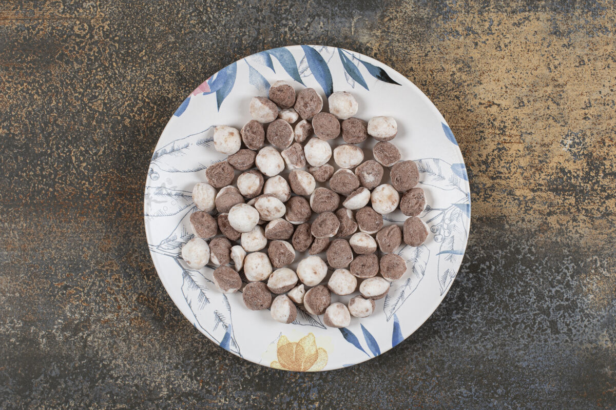 邦邦美味的棕色糖果放在五颜六色的盘子里零食巧克力美味