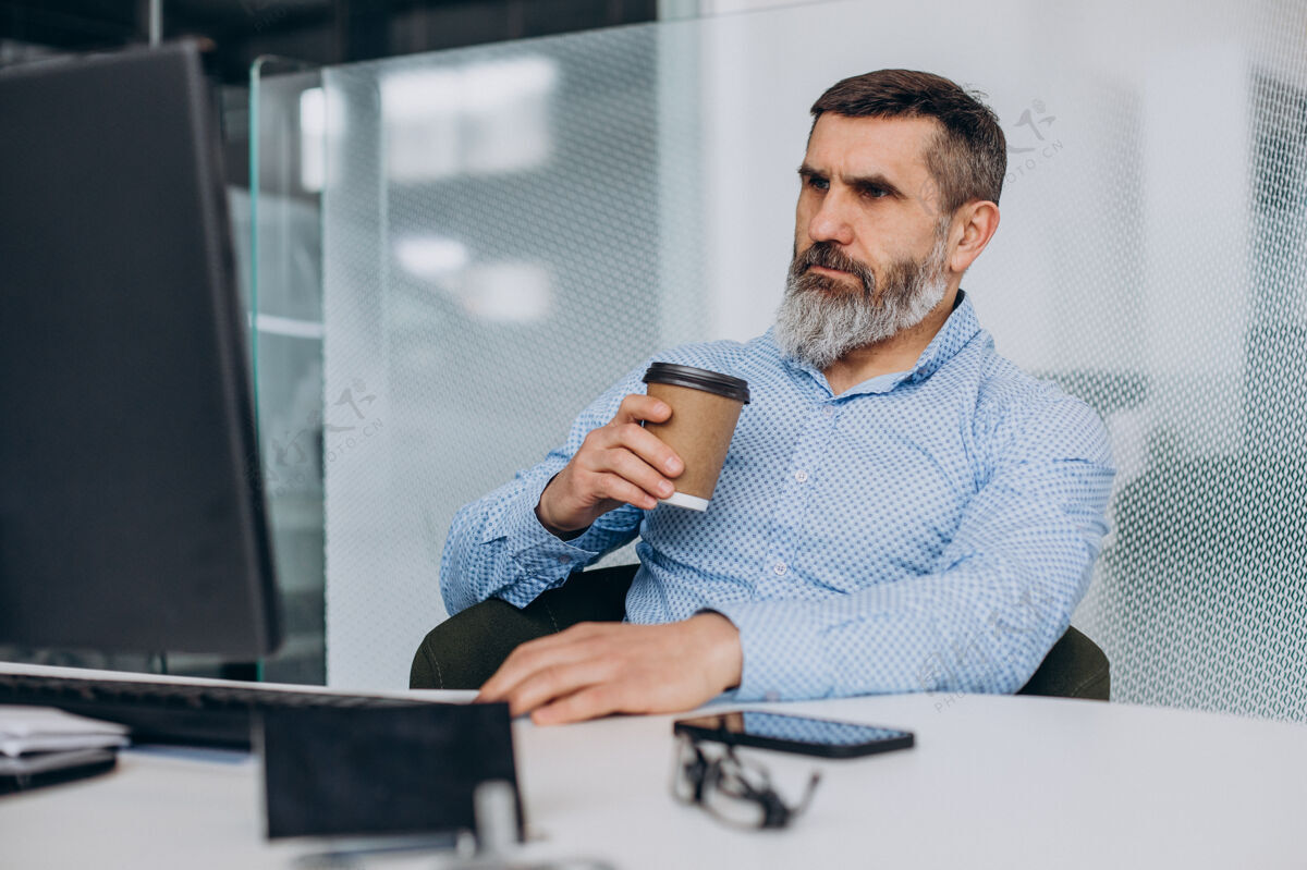 咖啡帅气的高级商务人士在办公室里操作电脑成熟成功的商人科技
