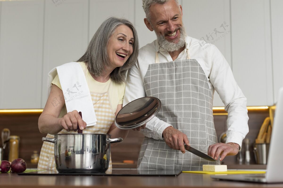 水平老两口在厨房用笔记本电脑上烹饪课设备有乐趣房子