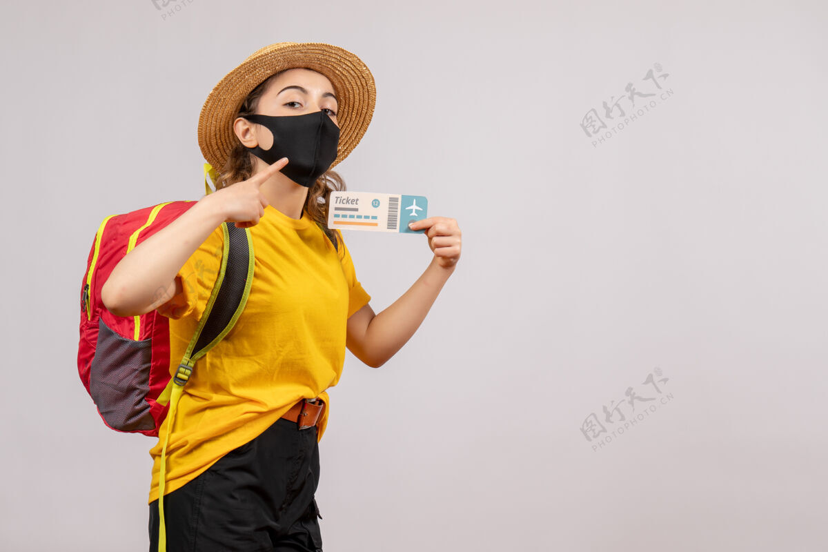 面罩正面图：年轻的旅行者背着红色的背包举着车票票度假向上