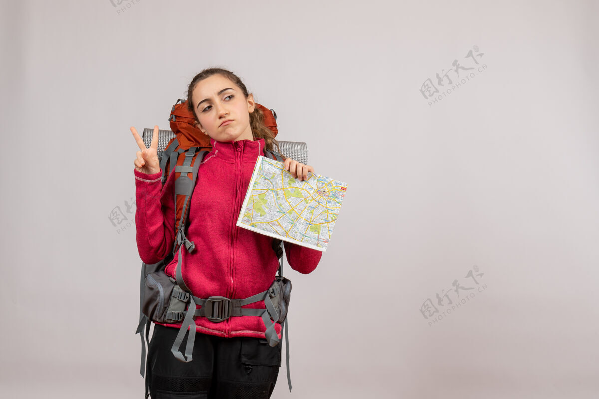 美丽正面图年轻的旅行者背着大背包拿着地图在做胜利的标志旅行者肖像背包