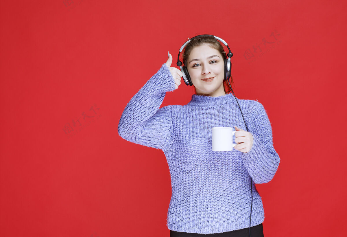 女性戴着耳机拿着咖啡杯微笑的女孩服装聪明工人