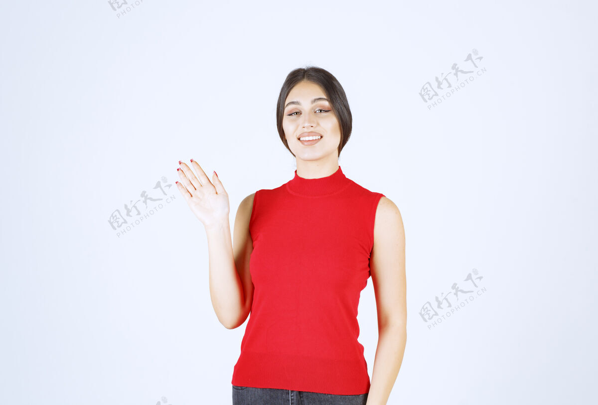 会议穿红衬衫的女孩问候或邀请某人人类熟人模特