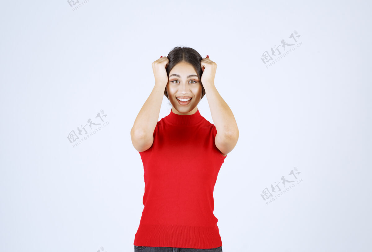 人穿红衬衫的女孩摆出积极诱人的姿势年轻休闲员工