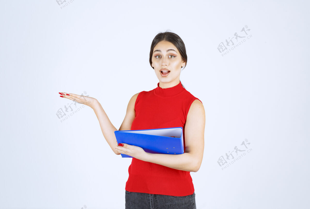 模特穿着红衬衫的女孩手里拿着一个蓝色的商业文件夹年轻人人类女性
