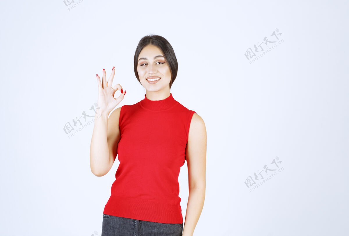 模特穿红衬衫的女孩展示着快乐的手势幸运女人年轻人