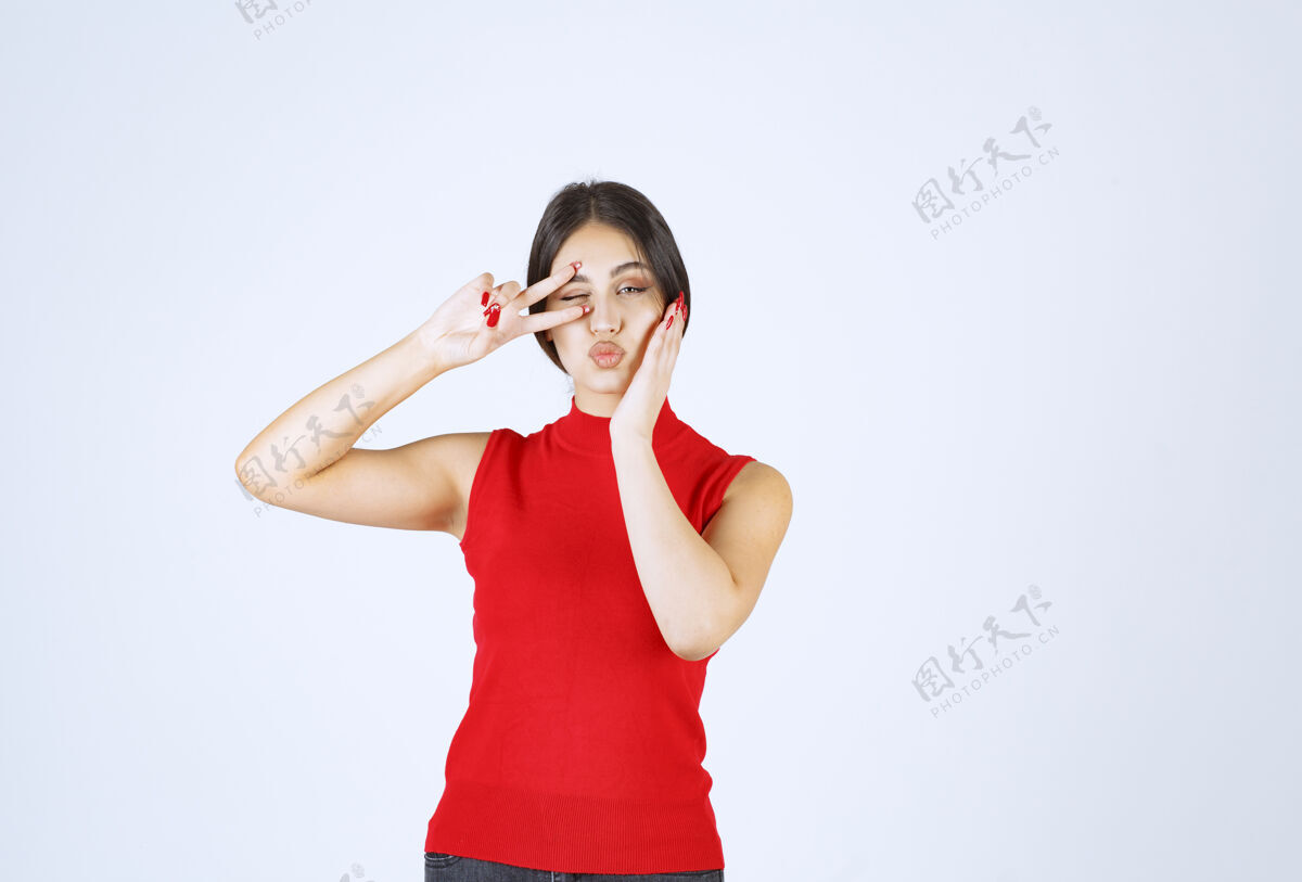女人穿红衬衫的女孩眨眨眼 表示满意成人积极年轻人