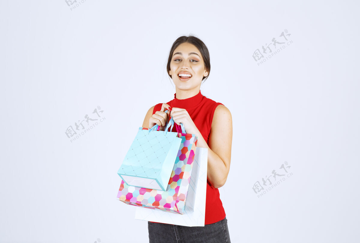 工人带着五颜六色购物袋的女孩感觉很积极年轻人模特年轻