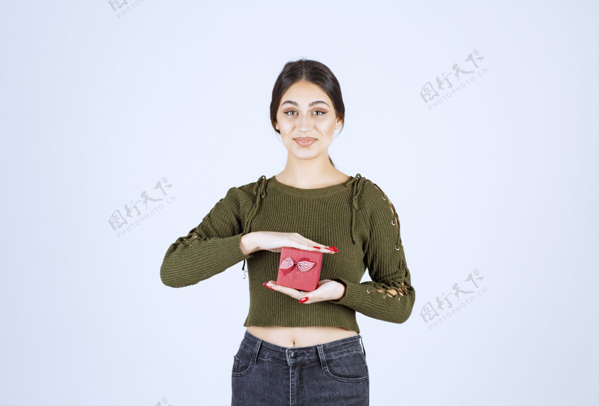 丝带年轻女子拿着礼品盒 看着白色背景上的相机人欢呼礼物