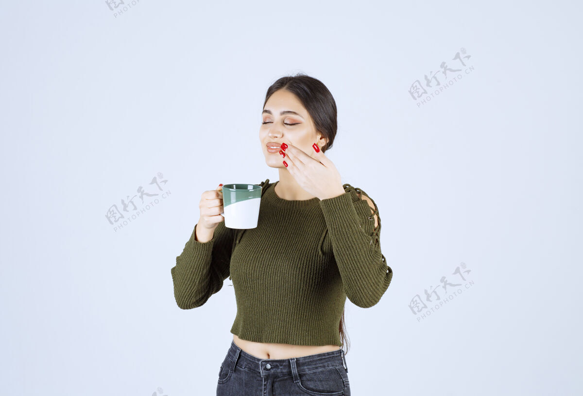 水一个年轻漂亮的女模特在喝一杯热茶杯子女孩杯子