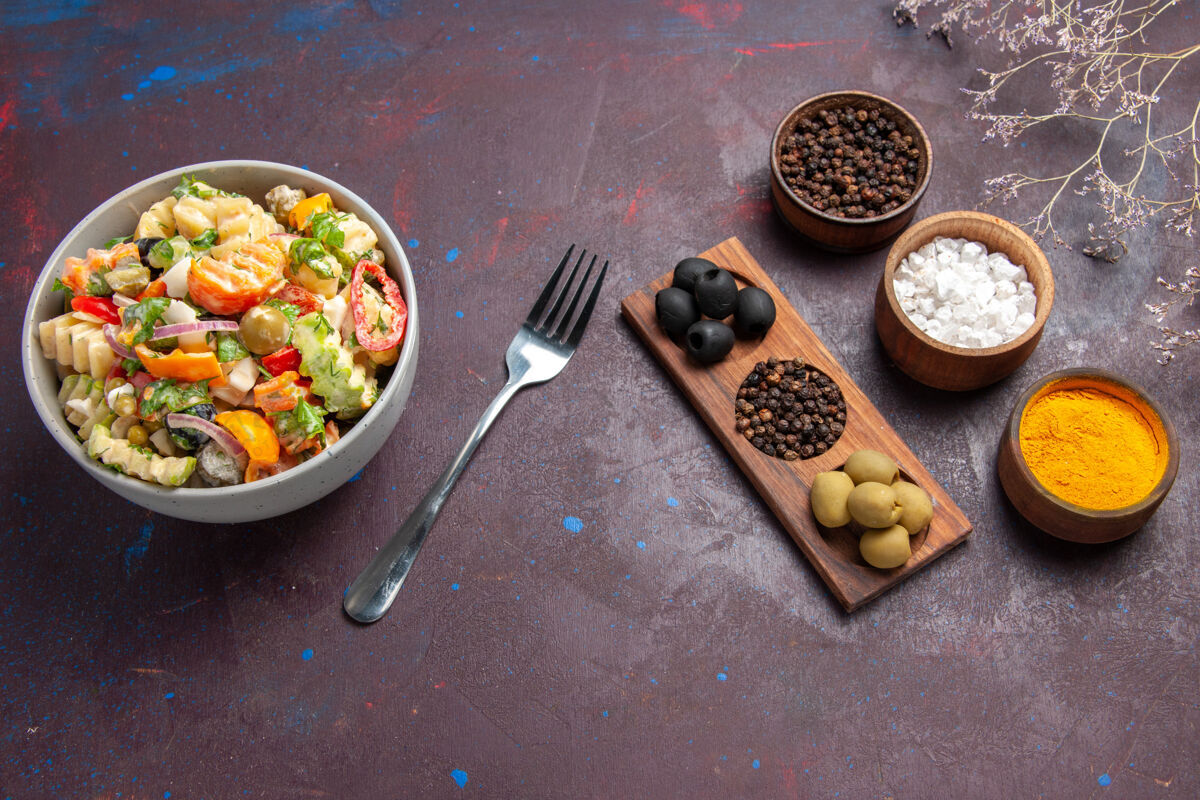 晚餐顶视图美味的蔬菜沙拉与不同的调味品对一个黑暗的背景健康沙拉餐饮食蔬菜坚果膳食