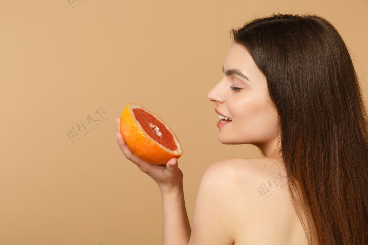 美容近景半裸体女人完美的皮肤裸妆举行葡萄柚隔离米色粉彩墙上护理室内赤膊