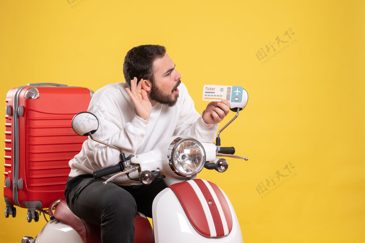 男人年轻人坐在摩托车上 提着手提箱 出示车票 听着黄色的最后一句闲话摩托车手提箱车辆