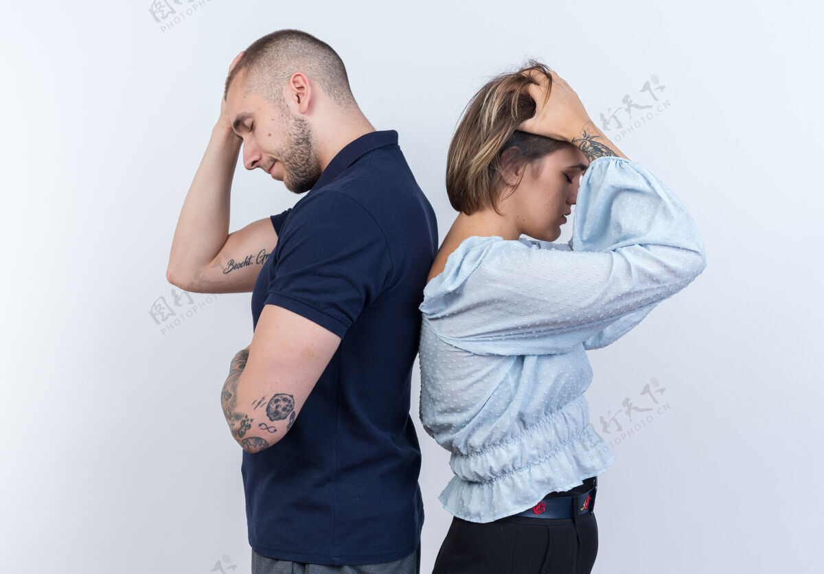 男人年轻漂亮的夫妇在白墙上背靠背地站着吵架女人站姿势