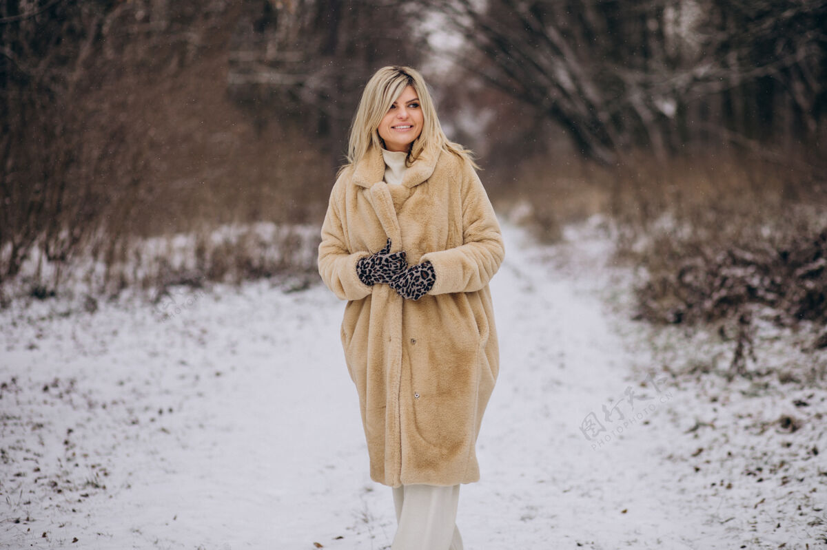 树穿着冬衣的美女在满是雪的公园里散步旅程美丽探索