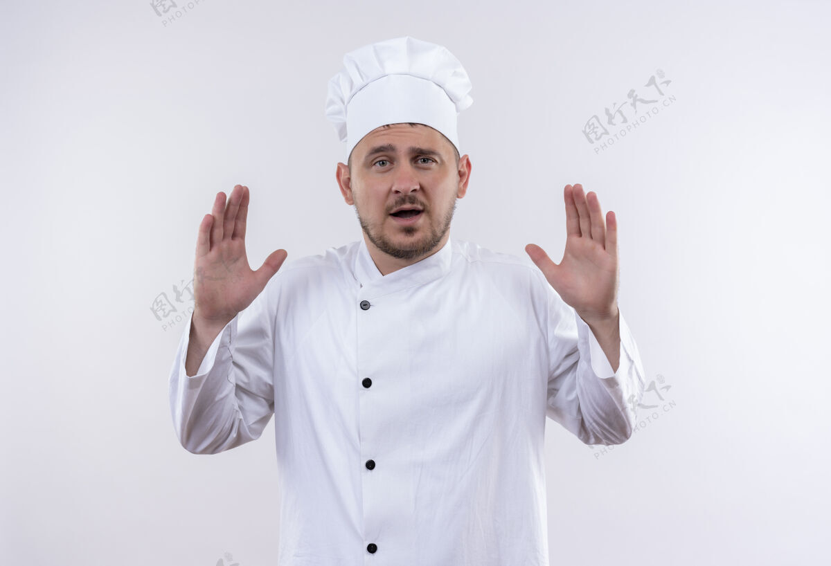 印象年轻帅气的厨师身着厨师制服 双手空空地孤零零地站在白色的墙上手秀年轻
