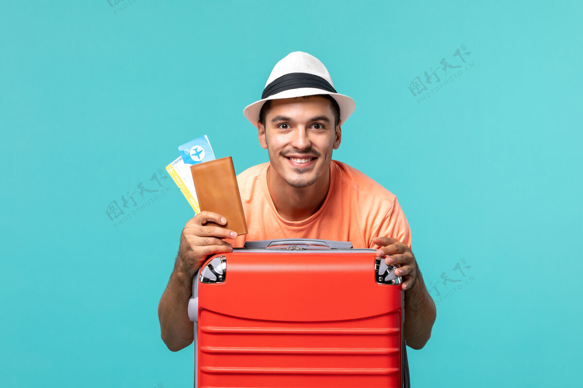 旅行度假的男人拿着他的票 脸上露出蓝色的微笑成人人航行