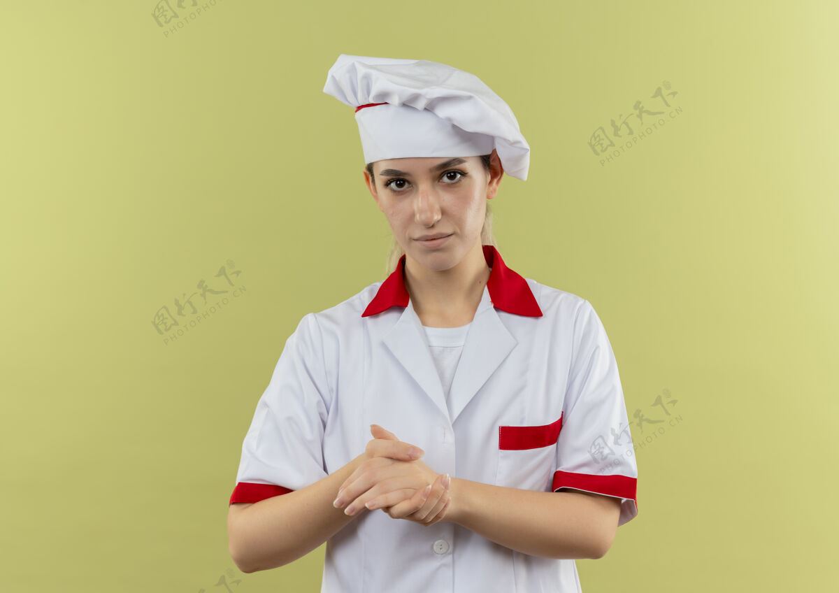一起自信的年轻漂亮厨师穿着厨师制服 双手在绿墙上保持着隔离厨师保持制服