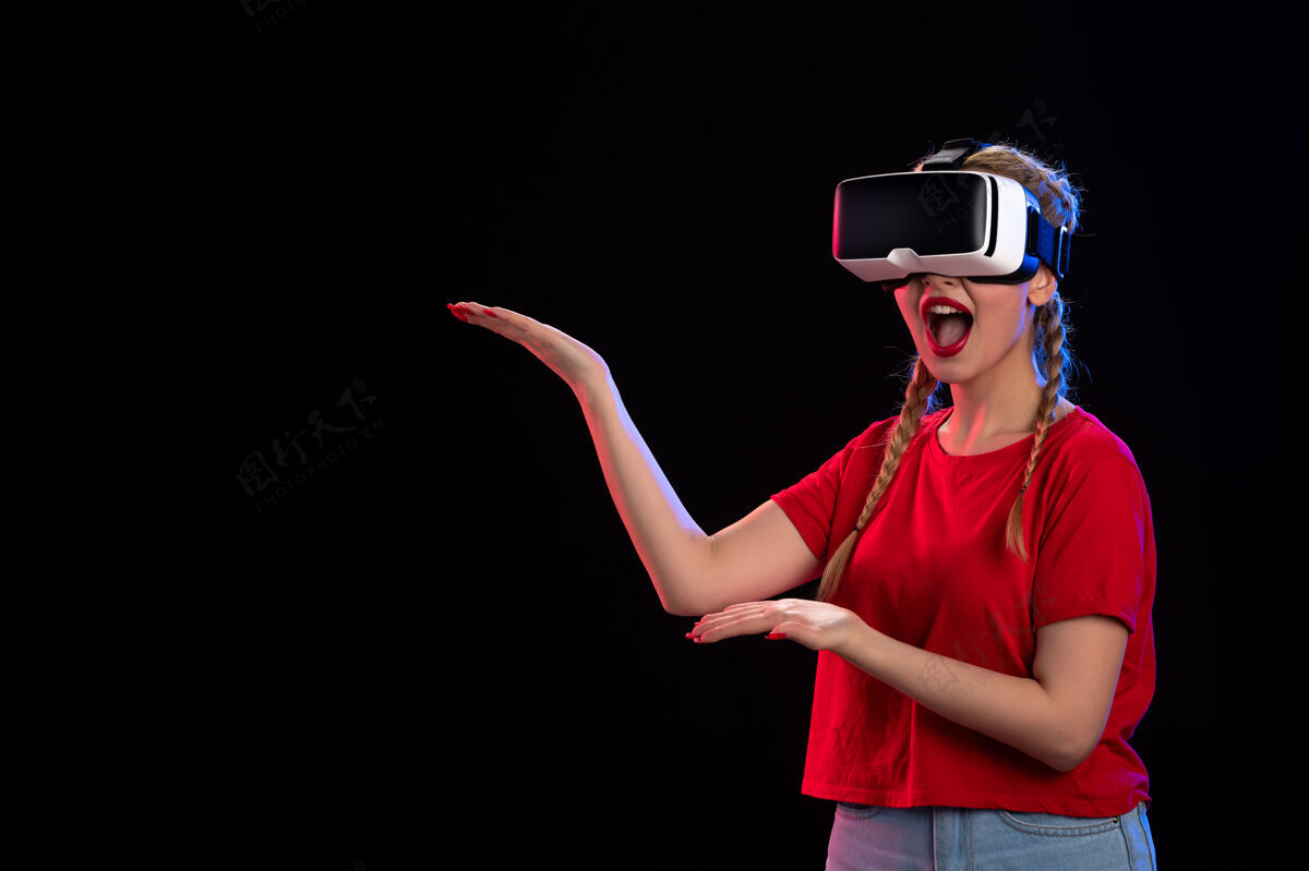 成人年轻女性在黑暗的墙上玩虚拟现实的正面图肖像视图视觉
