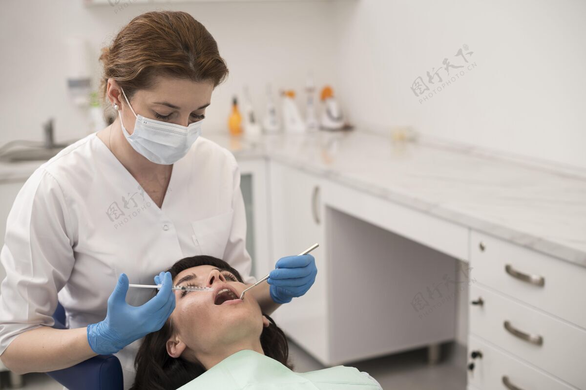 女性年轻的女病人在正畸医生那里做牙科手术医疗工人牙医